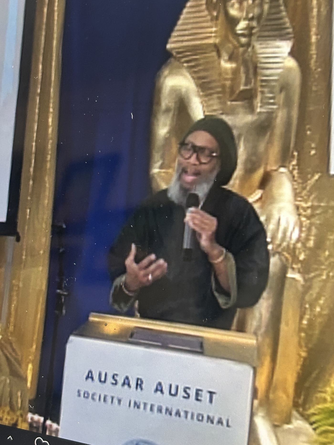 Heru TchaasAmen speaking at an Ausar Auset Society International podium