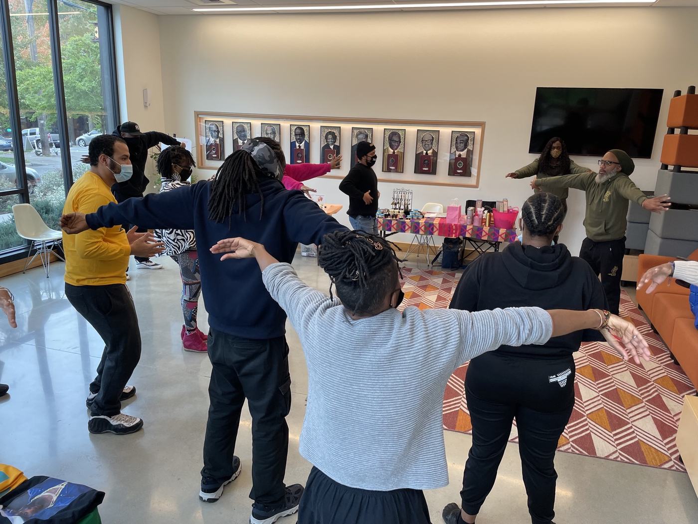 A group practicing Qigong together at the Liberty Bank Building, arms raised