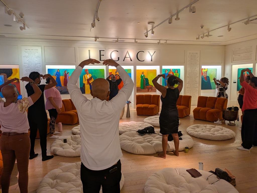 A group practicing a shared hand gesture at WOW Gallery