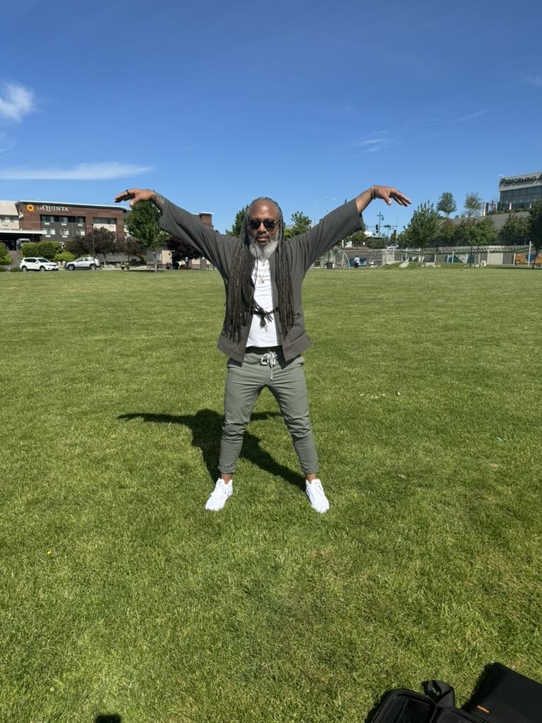 Heru TchaasAmen practicing Qigong outdoors in a field