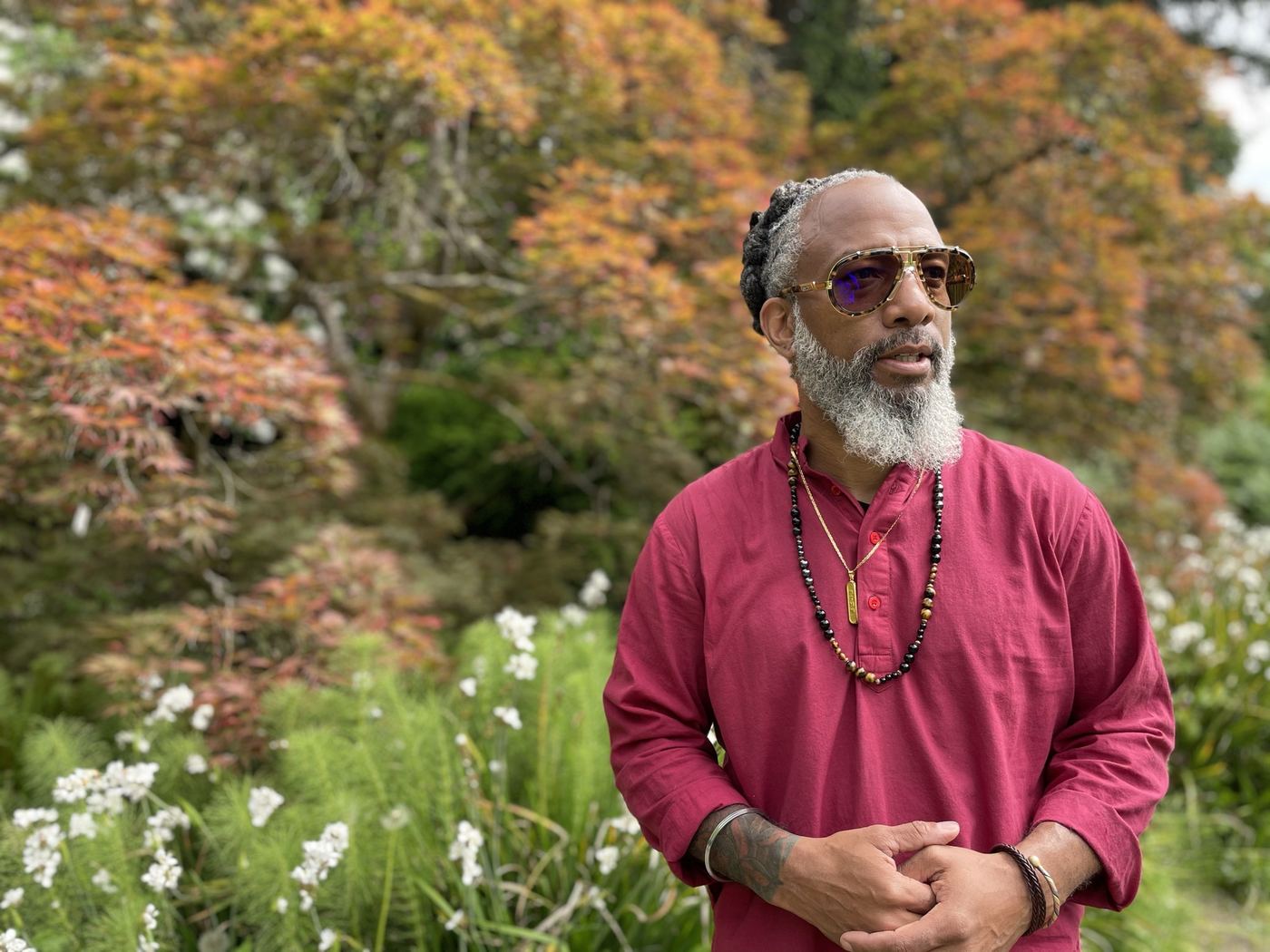 Heru TchaasAmen standing in stillness in a garden